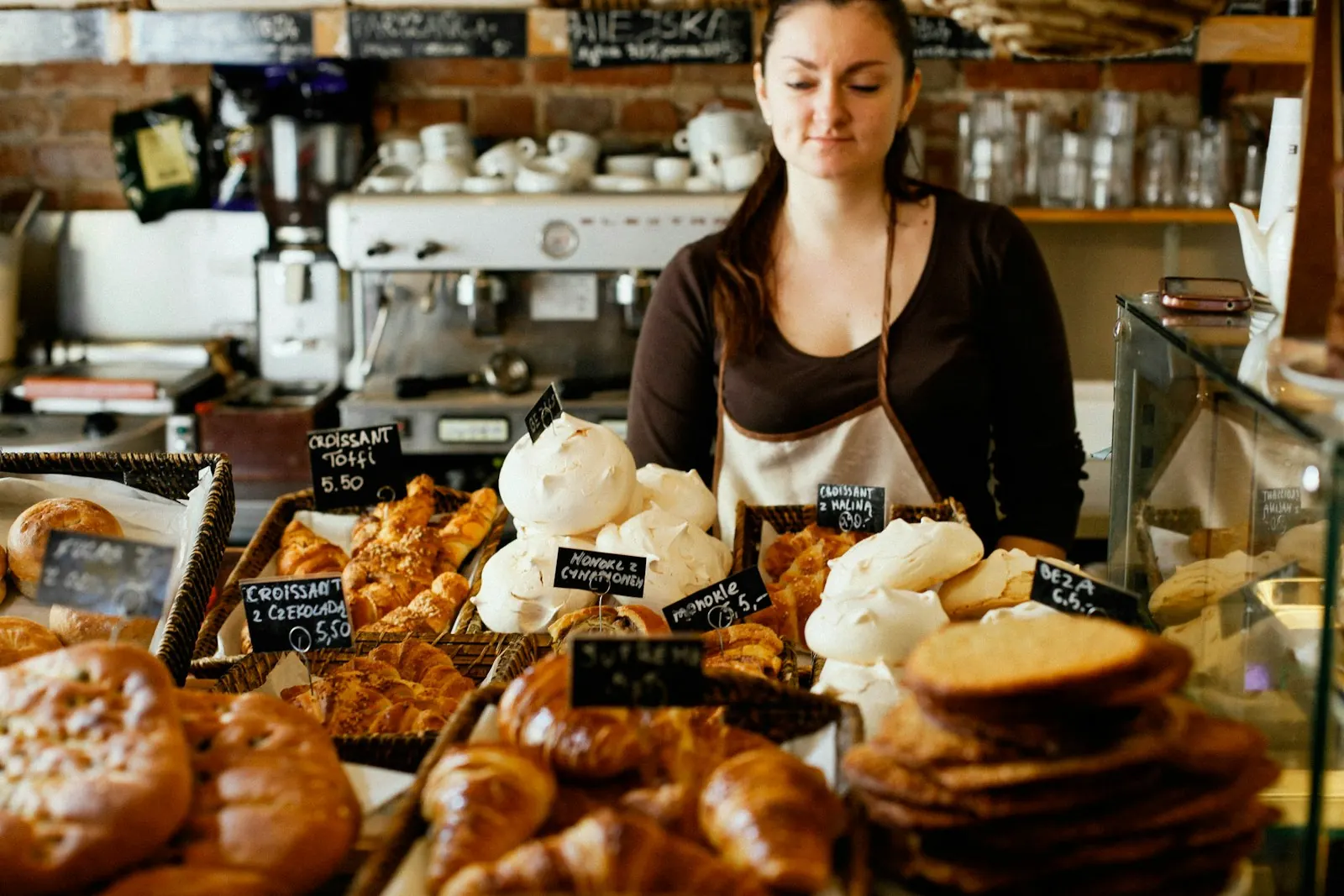 Bakery owner behind the pastry counter of her shop